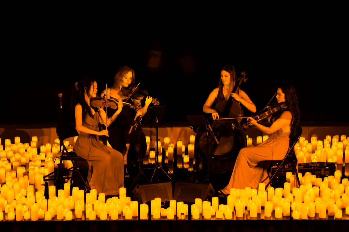 A string quartet performing surrounded by hundreds of candles.