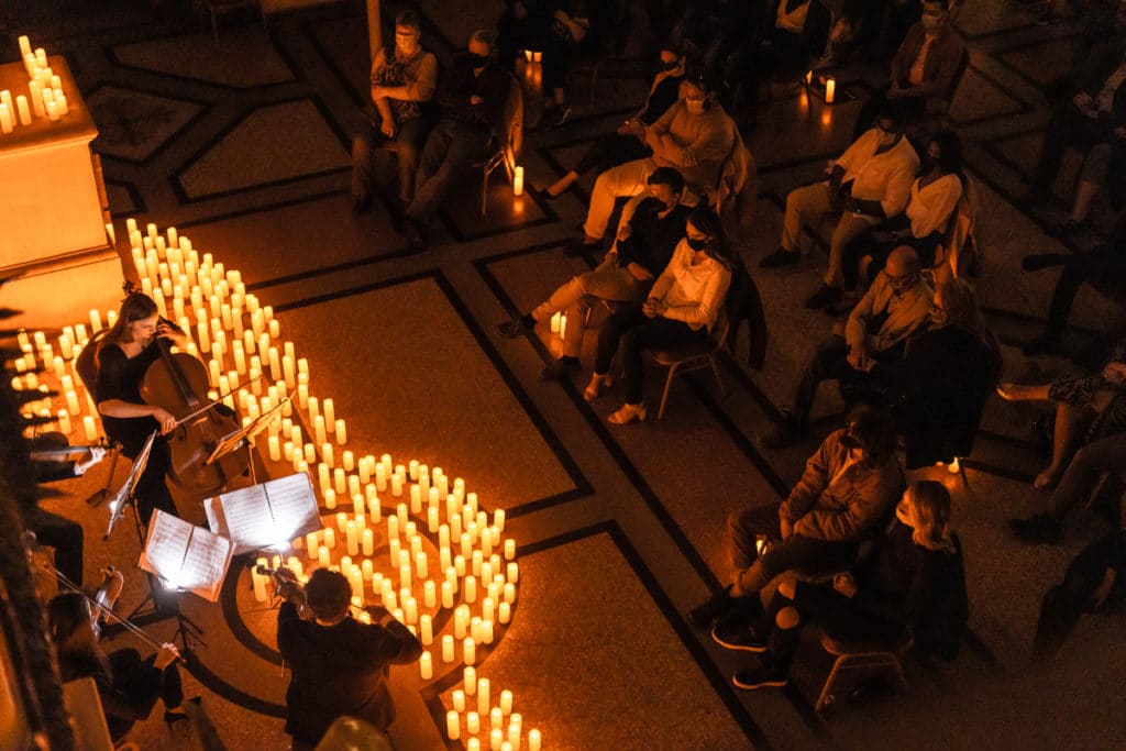 audience enjoys string quartet in concert under candlelight