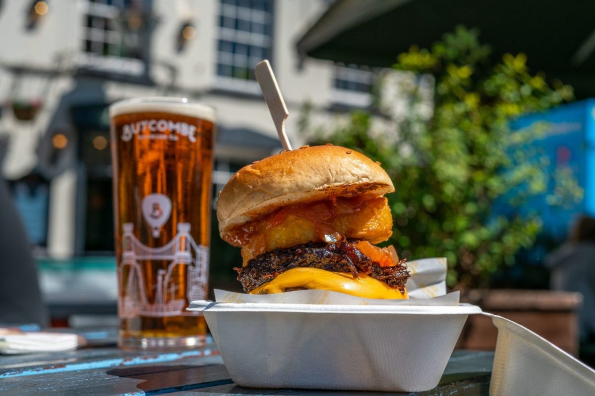pint-of-butcombe-beer-and-burger-with-onion-ring-on-beer-garden-table