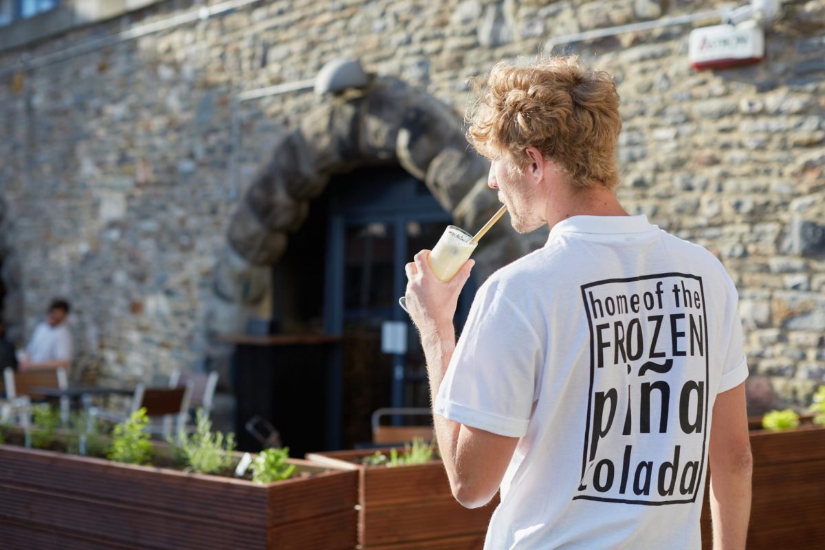 person-sipping-frozen-pina-colada-outside-harbour-hub-bristol