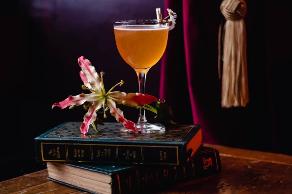 A Hyde & Co cocktail resting on three books