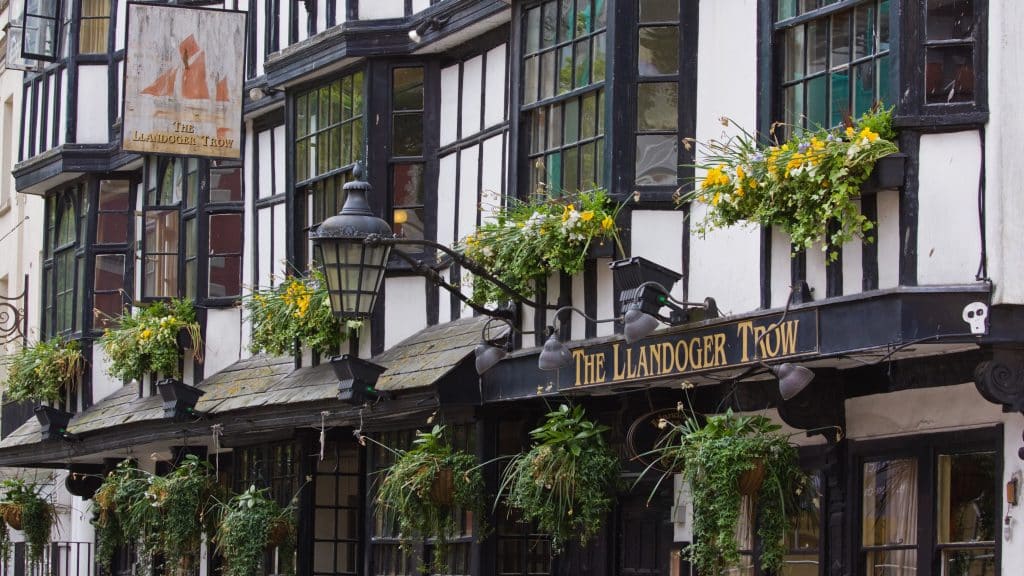Outside of The Llandoger Trow, with timber frames and green shrubbery growing outside