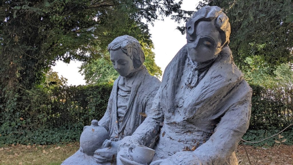 A statue of mysterious artist Getting Up To Stuff of Vanessa Hughes sat with an unknown person