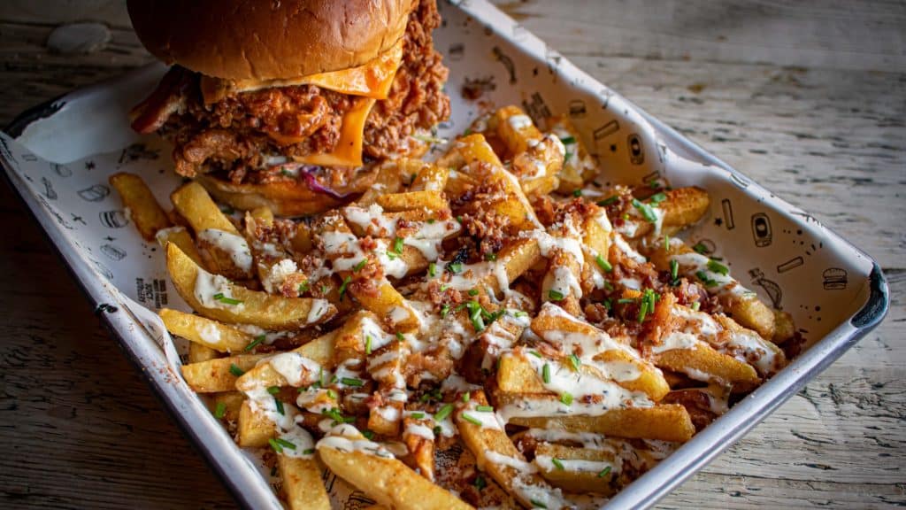 A tray of loaded fries and a burger from Fat Hippo