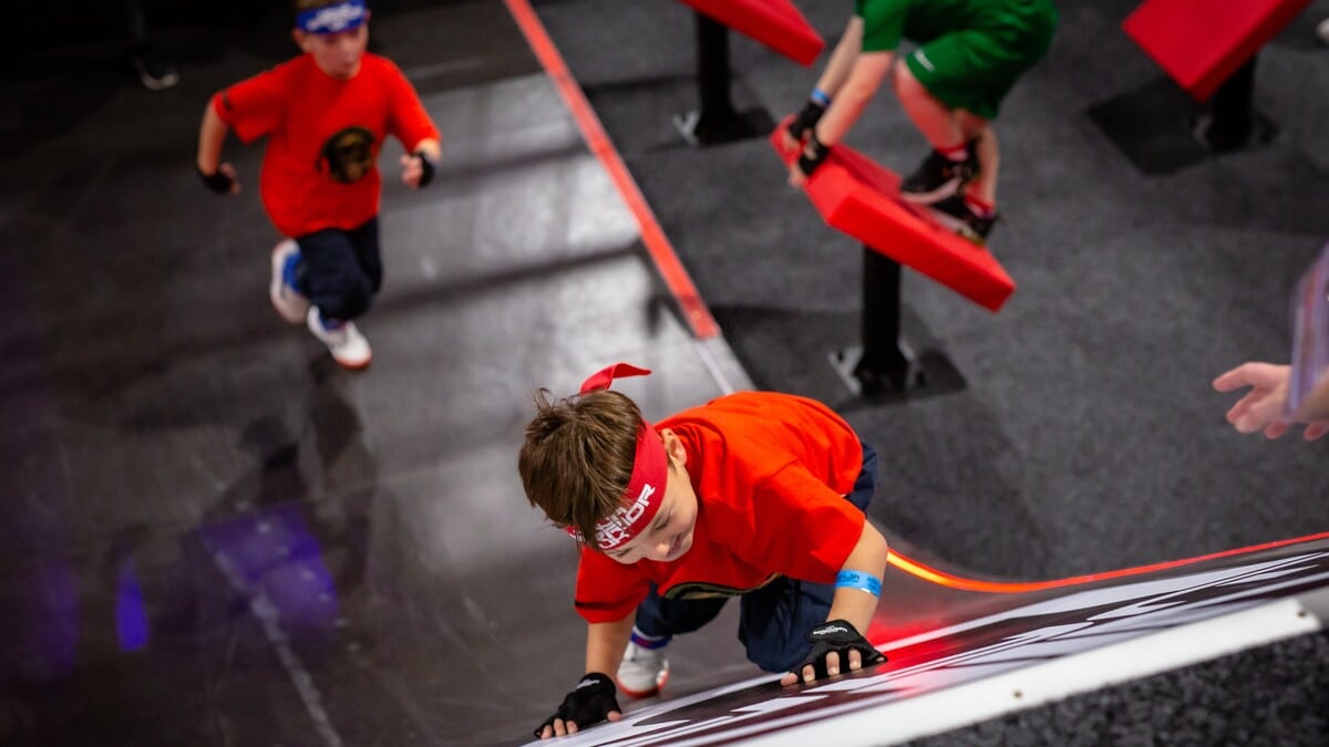 Children climbing obstacles at Ninja Warrior Adventure Park, one of the best things to do with kids in Bristol