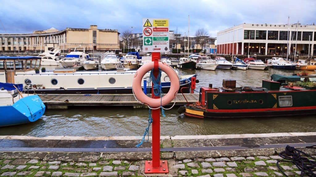 A lifebelt and a sign warning that swimming is not allowed in the Bristol Harbour