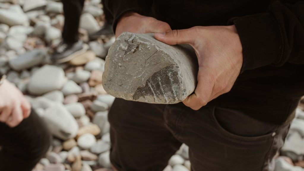 A man holding a fossil on Kilve Beach