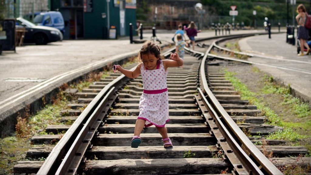 A child runs on a disused habourside railway in Bristol
