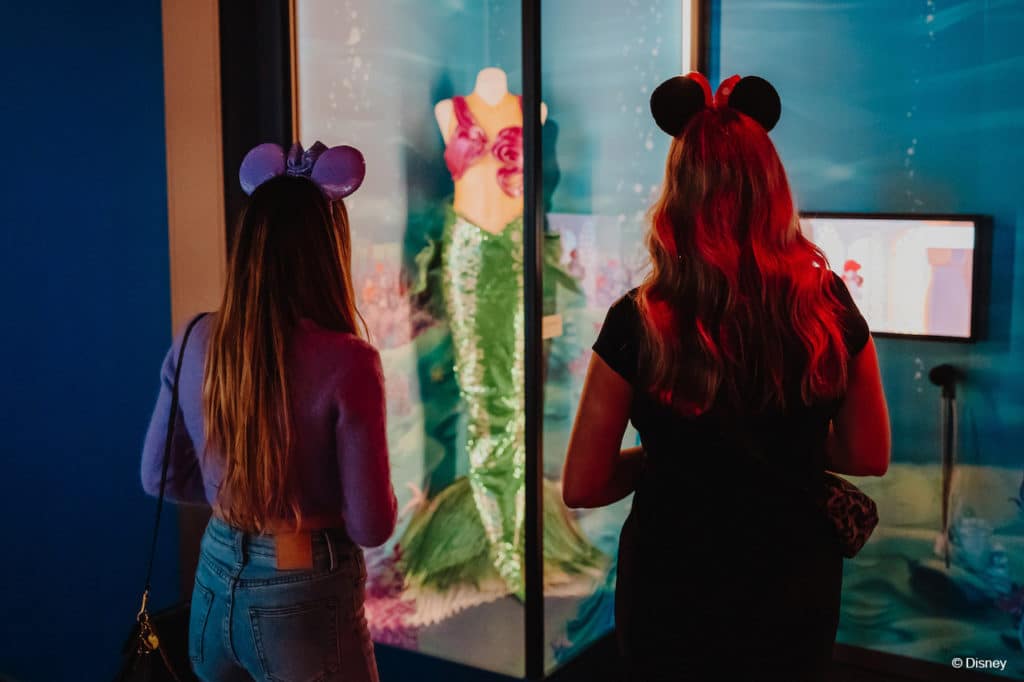 two women admiring the Little Mermaid costume at Disney100: The Exhibition