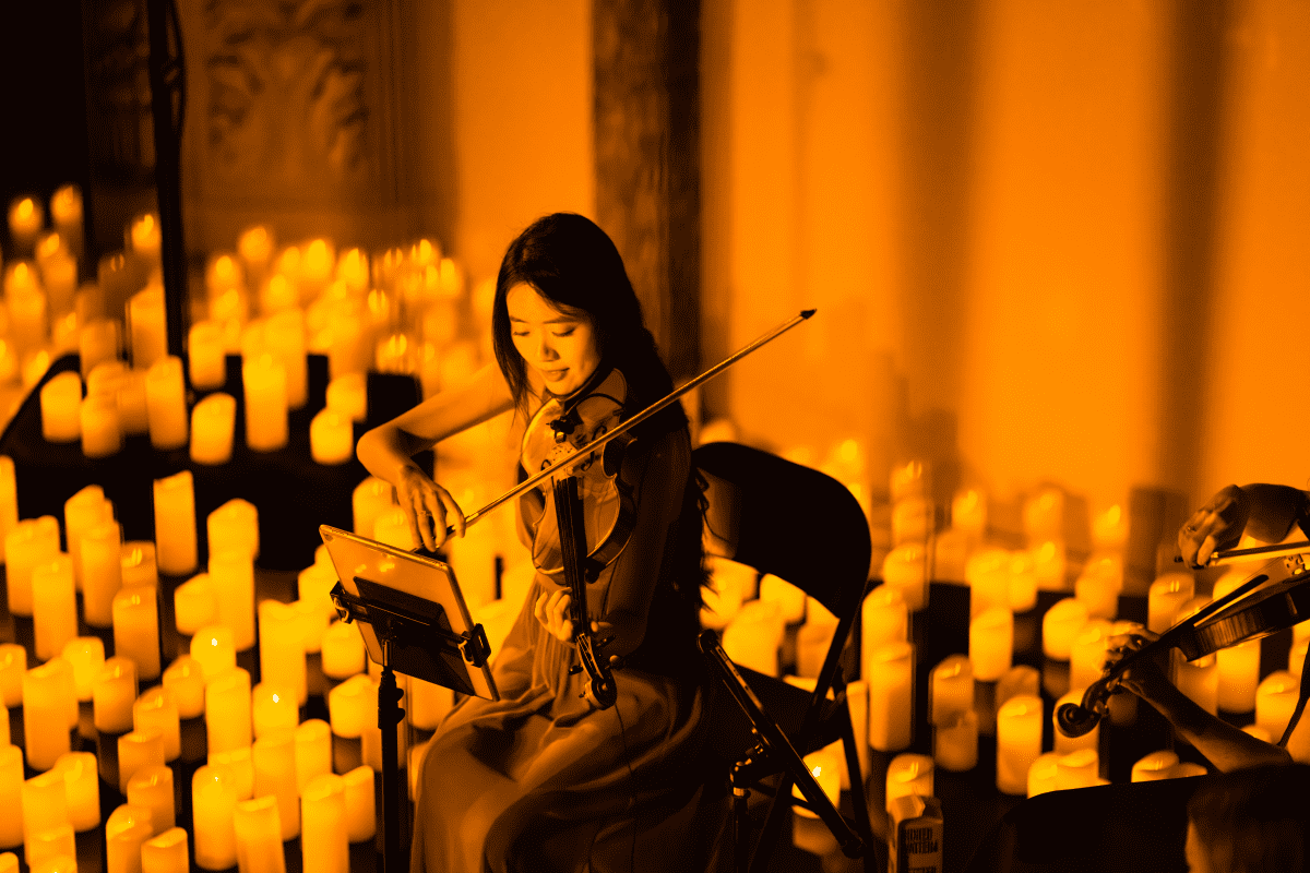 A violinist performing by candlelight